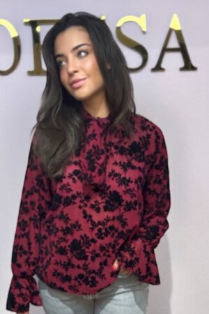 Bordeauxrode blouse met zwarte bloemenprint, strikkraag en ruffel. One size tot maat 42. Gemaakt van 100% polyester. Elegant en comfortabel.