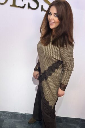 Model draagt een lange bruine tuniek met ruitpatroon en zwart kant dat schuin in een punt naar beneden loopt – one size tot maat 44.
