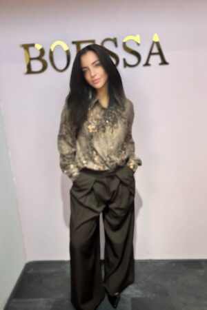 Model draagt een oversized luxe blouse met pailletten in taupe. Losvallend model met glanzende details.