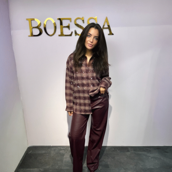 Model draagt een vegan leren croco pantalon in bordeaux met rechte pijp, steekzakken en high waist pasvorm.