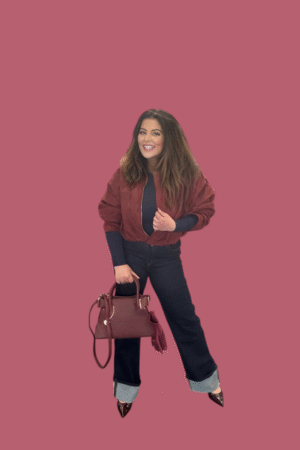 Donkerblauwe high waist jeans met brede omslag aan de pijpen, geschikt voor lange benen, gedragen met gouden sieraden en designerhandtas.